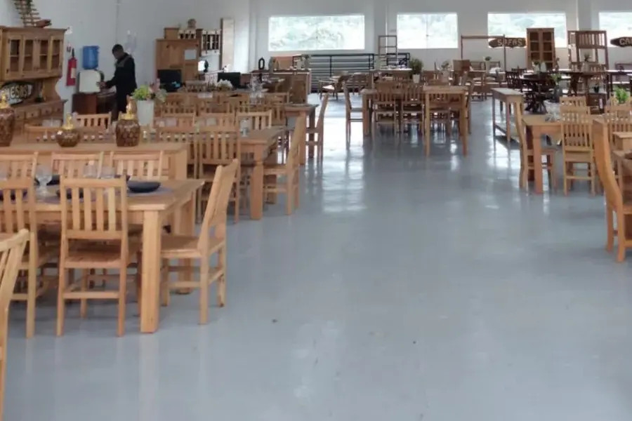 Mesas e cadeiras de madeira maciça no showroom da Arte Velha